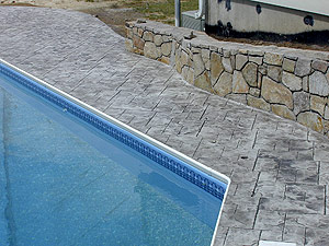 Stamped concrete pool deck that looks like natural stone.