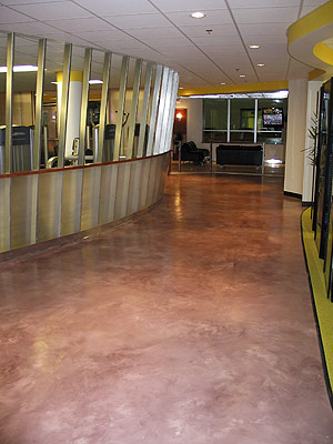 Concrete lobby that is stained in a light reddish color that contrasts the yellow walls.
