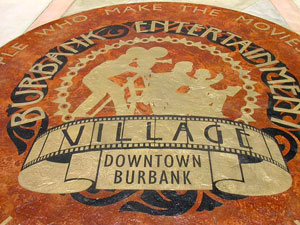 Downtown Burbank Village logo on a concrete outdoor space.