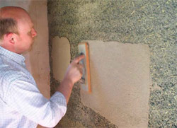 Lime Technology managing director Ian Pritchett applies samples of lime render on an interior wall of the chapel.