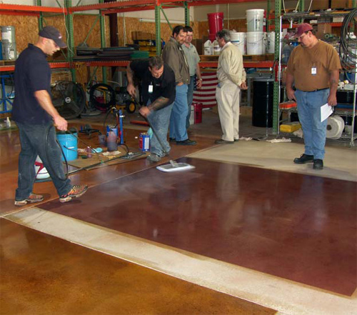 Jason Campbell (with sprayer) and Gary Vidal (with mop) of American Decorative Concrete Supply Co. show observers the correct way to apply ColorJuice to floors. They are spreading ADCSCs Proguard Stain Shield after a ColorJuice application. ADCSC conducts training at its facility every three months.