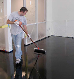 A man applying the coating to this floor using a broom technique.